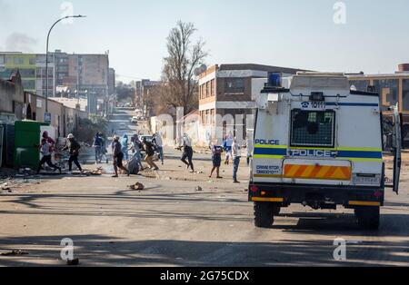 Johannesburg, South Africa. 11th July, 2021. Protestors are dispersed by police during a protest against the incarceration of former president Jacob Zuma in Johannesburg, South Africa, July 11, 2021. The South African police said on Sunday that they have arrested 62 people in KwaZulu-Natal and Gauteng Province as people protested against the incarceration of former president Jacob Zuma. TO GO WITH 'S. African police arrest 62 after violent protests' Credit: Yeshiel/Xinhua/Alamy Live News Stock Photo