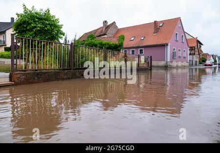Willersdorf, Germany. 11th July, 2021. The Aisch river has overflowed its banks and flooded parts of the village of Willersdorf. Parts of Franconia are still under water due to yesterday's high water. Credit: Nicolas Armer/dpa/Alamy Live News Stock Photo