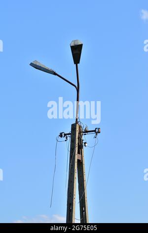 Broken electric wires on the pole and on the lamp. Summer. Stock Photo