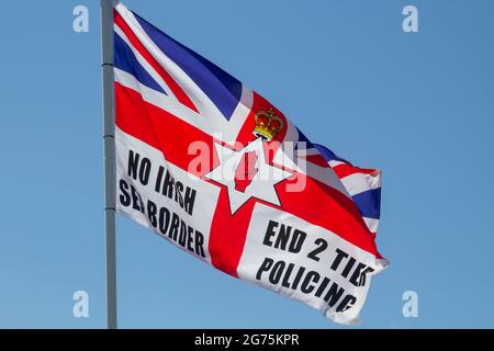 11 July 2021 A Union Flag with political slogans flying beside the annual bonfire in the kilcooley Estate in Bangor County Down Northern Ireland Stock Photo