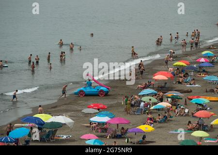 Malaga, Spain. 11th July, 2021. People cool off on the beach during a hot summer day at Rincon de la Victoria.Spain live its first heat wave with high temperatures near 45º degrees in many cities of the country, according to the Spanish Meteorological Agency. Spaniards take advantage of beaches to cool off at the Mediterranean Sea and enjoy good weather. Credit: SOPA Images Limited/Alamy Live News Stock Photo