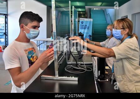 Calafell, Spain. 11th July, 2021. A young man registers himself to receive a Covid-19 vaccination at the check-in point at the Calafell Vaccination Center. The Department of Health of Catalonia through the Xarxa Santa Tecla de Tarragona in prevention against the contagion of SARS-CoV-2 Covid-19 has administered the first dose of the COMIRNATY vaccine (COVID-19 mRNA vaccine, Pfizer-BioNTech) to people between the ages of 16 and 34 at the vaccination center located at the Joan Ortoll Sports Pavilion in Calafell. Credit: SOPA Images Limited/Alamy Live News Stock Photo