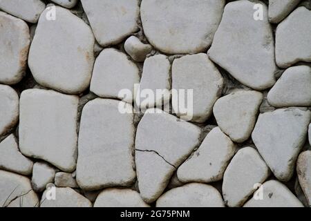 Wall cladding made using rounded stones. Stock Photo