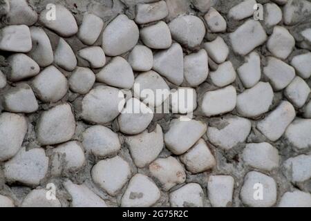 Wall cladding made using rounded stones. Stock Photo