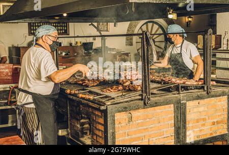 Chefs in Face Mask Using Grill Stock Photo