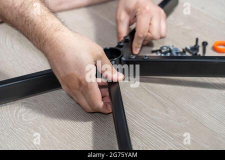 a man assembles a new chair at home. Stock Photo