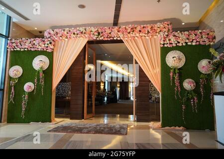 Floral Wedding decoration element. Lights, entrance gate, Shower, Flowers, Couple Stage. Closeup beautiful flowers wedding arch at the entrance of the Stock Photo