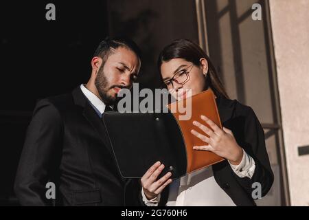 A closeup of two Hispanic people, man and woman, looking through a journal. Stock Photo