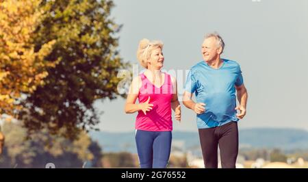 Senior woman and man running doing fitness exercises Stock Photo