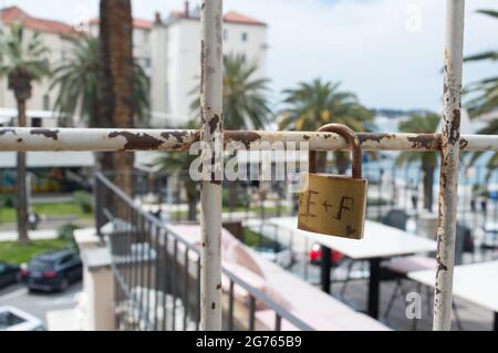 Old and rusty love padlock locked on the rusted iron fence in Split, Croatia, symbol of eternal love Stock Photo