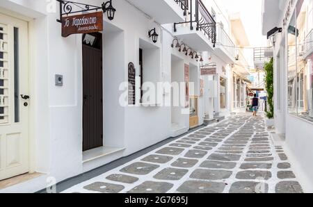 Greece, Paros island. Cyclades. May 20, 2021. Naousa town traditional architecture, whitewashed buildings, shops on narrow cobblestone alleys. Summer Stock Photo