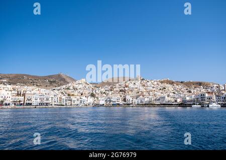 Syros island, Cyclades, Greece. May 27, 2021. Panoramic view of Hermoupolis summer destination capital of Siros or Syra town background. Port with moo Stock Photo