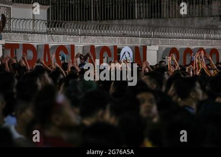 Filipino Catholic devotees raise miniature replicas of the Black Nazarene in Manila. A mammoth crowd of mostly barefoot Filipino Catholics prayed for peace in the increasingly volatile Middle East at the start of an annual procession of a centuries-old black statue of Jesus Christ in one of Asia's biggest religious events. Philippines. Stock Photo