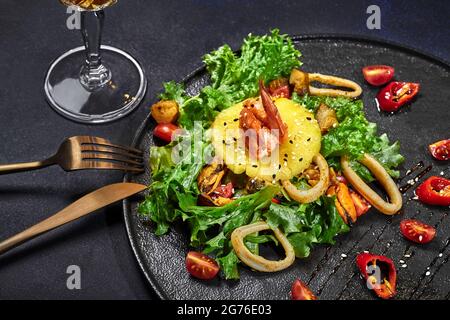 Salad of fried squid, mussels, scallops and shrimps with vegetables and pineapple Stock Photo