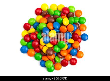 A Pile of Rainbow Colored Candy Coated Chocolate Buttons Isolated on a White Background Stock Photo