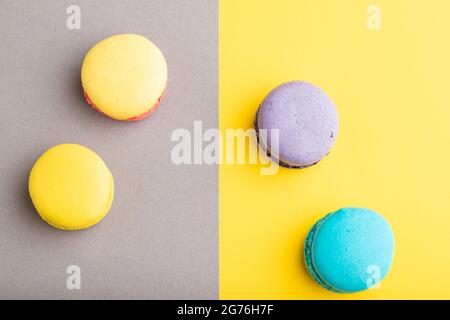 Yellow, purple and blue macaroons on trendy gray and yellow background. top view, copy space, close up, still life. Minimalism, morning, contrast conc Stock Photo