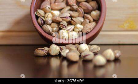 Dried fruits in a pot clay, dried nuts and fruits on a wooden background, selective focus Stock Photo