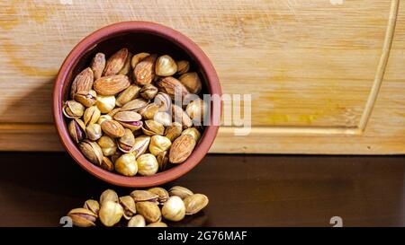 Dried fruits in a pot clay, dried nuts and fruits on a wooden background, selective focus Stock Photo