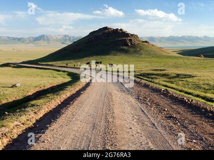 Unpaved road and yurts near Son-Kul lake and Tian Shan mountains in Kyrgyzstan Stock Photo