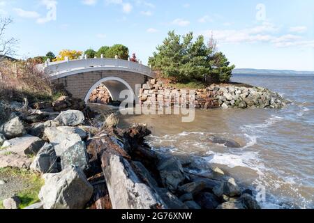 Rocky shore with an arched bridge over the sea water at Tacoma, Washington Stock Photo