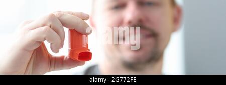 Man holds an inhaler in his hand. Stock Photo