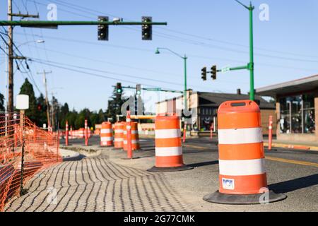 Carnation, WA, USA - July 11, 2021; Construction barrels and orange safety fencing in downtown Carnation as a part of an infrastructure improvement Stock Photo