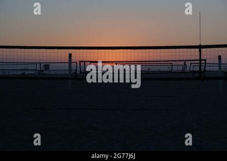 The sun sets on a southern California beach and highlights the beach volleyball courts. Stock Photo