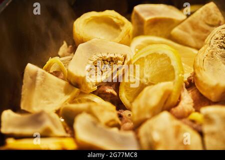 Lamb with lemon, artichokes and coriander stalks are fried over low heat in cauldron Stock Photo