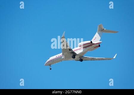 Bombardier BD-700-1A11 private small business jet preparing for landing at airport with deployed landing gear - San Jose, California, USA - 2021 Stock Photo
