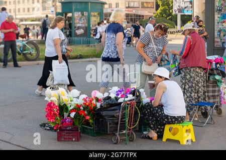 Female street vendors selling artificial flowers in the busy street spot, St. Petesrburg, Russia Stock Photo