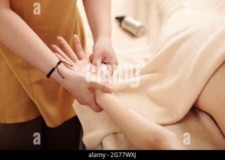 Therapist massaging hands of young woman with oils, beauty, pleasure and alternative medicine concept Stock Photo