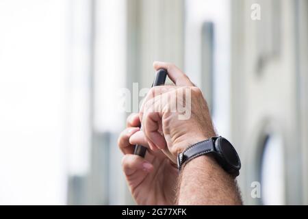 Mobile phone and mans hands with watch Stock Photo