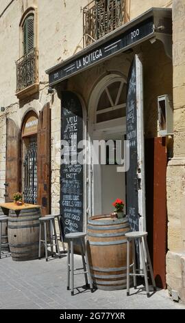 VALLETTA, MALTA - May 23, 2018: Empty seats outside the entrance to La Bottega bar and restaurant in Merchants Street, Valletta, Malta Stock Photo