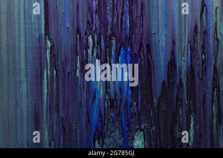 Neon paint drip on wall background Dark toned Stock Photo