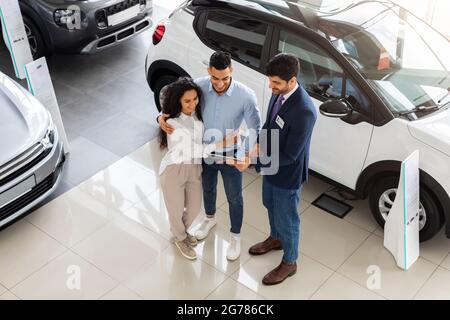 Arab couple visiting automobile showroom or exhibition Stock Photo