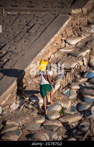 Yandebo, Mayanmar: Young girl collecting water for domestic use from the Irrawaddy River . Children are often engaged in this daily chore Stock Photo