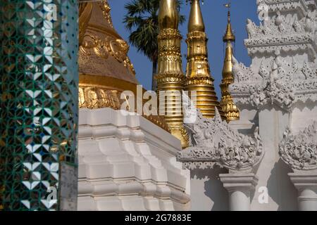 Shwedagon Pagoda, Yangon, Myanmar. Partial view to richly decorated temple complex, clad in mirror tiles and gold plate . Stock Photo