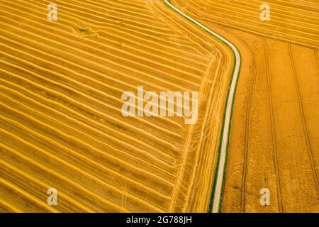 Aerial view of a freshly harvested wheat field. Beauty and patterns of a cultivated farmland from above. Stock Photo