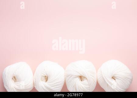 White clews of wool on a pink background. Place for your text. Top view - Image Stock Photo