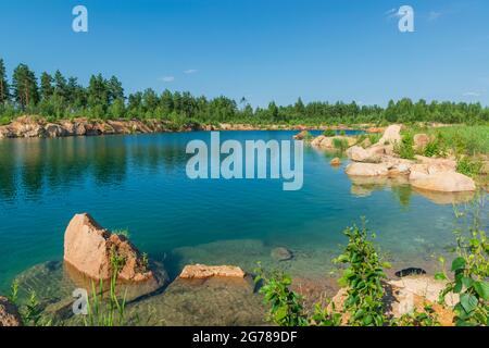 Crystal clear lake in the forest. A flooded quarry in Ukraine Stock Photo