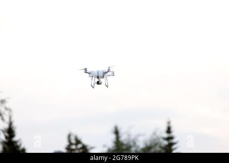Drone flying in sky with mounted digital camera used for photographing. quadcopter on sky background. Stock Photo