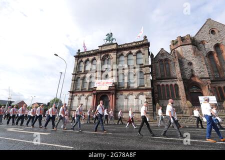 Orangemen march past Clifton Street Orange Hall in Belfast as part of the July 12 celebrations which marks the victory of King William of Orange over the catholic King James at the Battle of the Boyne in 1690. Stock Photo