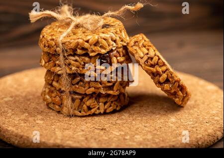 Homemade cookies with sunflower seeds and raisins tied with string on a wooden table. Close-up Selective focus Stock Photo