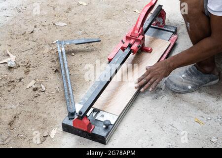 Worker cutting ceramic tile with tile cutter tool Stock Photo