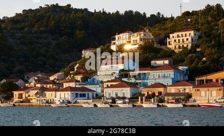 Ionian Islands, Ithaka, Bay of Molos, Vathi, view of the northeastern part of Vathi, in front of it boats, sun reflection in a window, behind it green hills, sky white Stock Photo