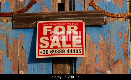 Ionian Islands, Ithaca, island of Odysseus, northwest, mountain village Exogi, weathered blue shutters, printed sign saying 'FOR SALE' Stock Photo