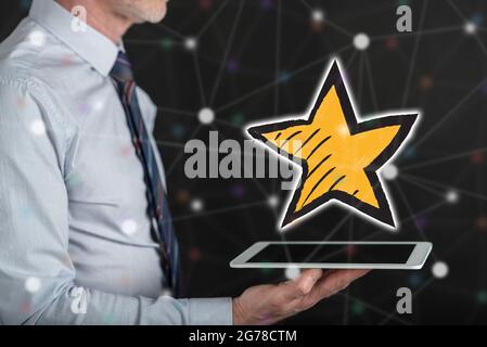Favorite star concept above a tablet held by a man Stock Photo