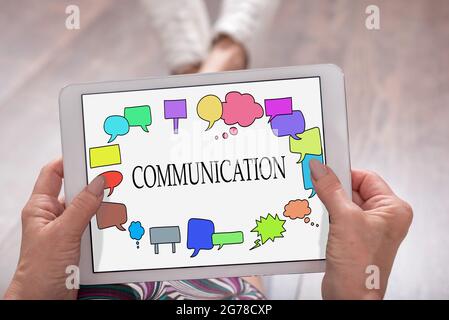 Communication concept shown on a tablet held by a woman Stock Photo