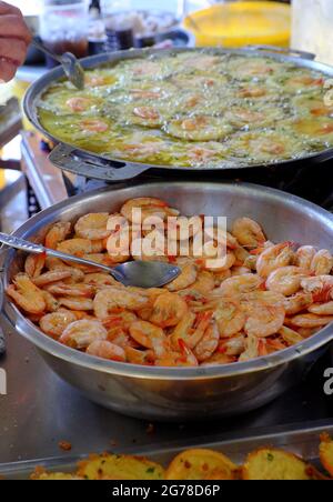 Vietnamese mini shrimp pancake and raw material, make yellow crispy cake, people make popular street food on coal stove at outside sidewalk restaurant Stock Photo