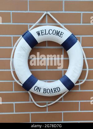 Blue and white colored lifebelt hanging on the brick wall of the sailing clubhouse Stock Photo